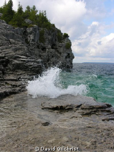 With the Limestone cliffs in the background, a wave 'cras... by David Gilchrist 